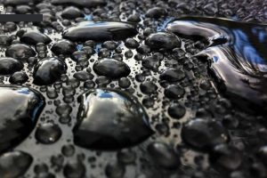 various sized water drops on tinted glass