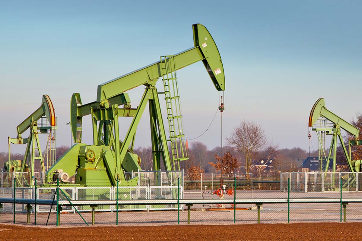 green oil suction cranes pumping oil from underground in the countryside